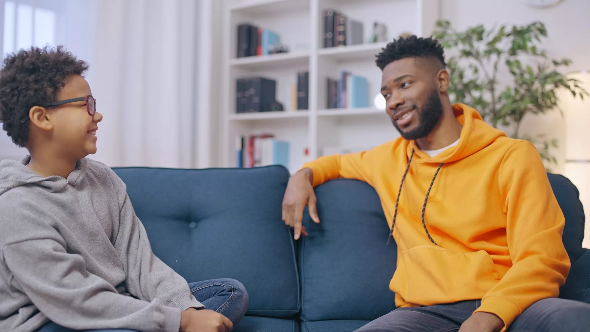 Young adult man talks with young teen boy