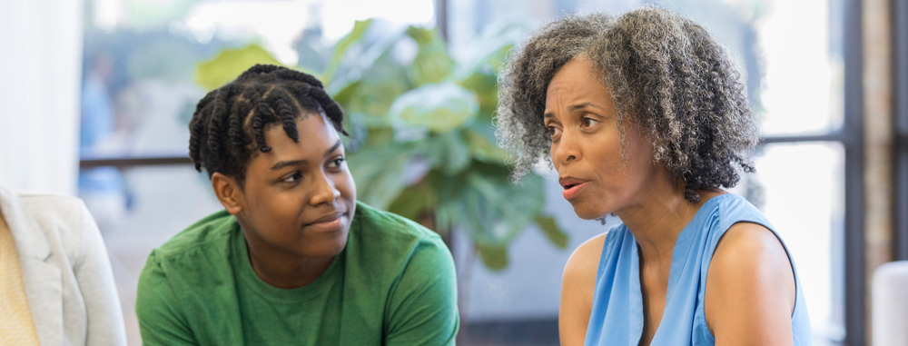 caregiver and teen boy in counseling setting