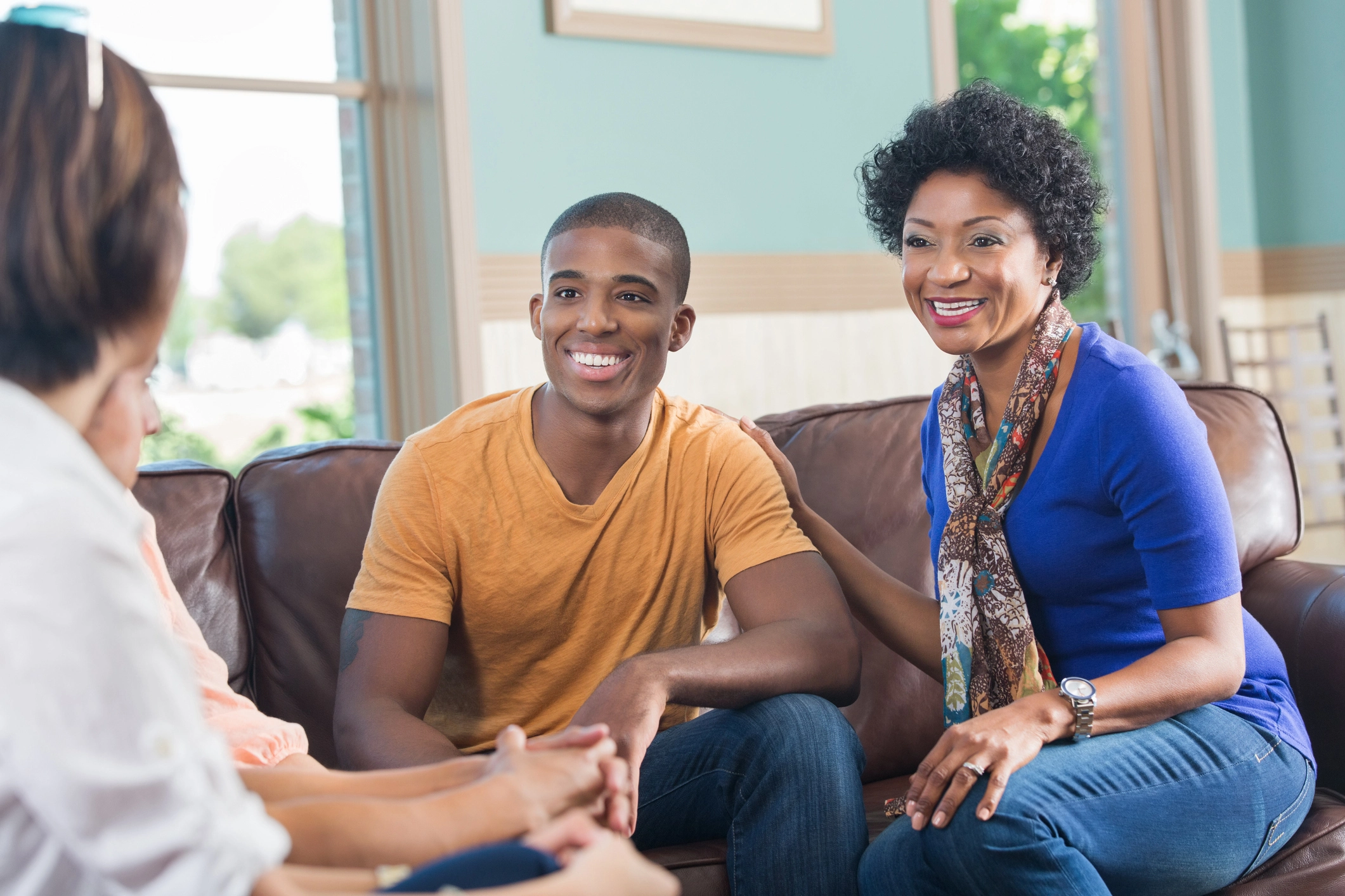 Teen boy with mother talking to therapist