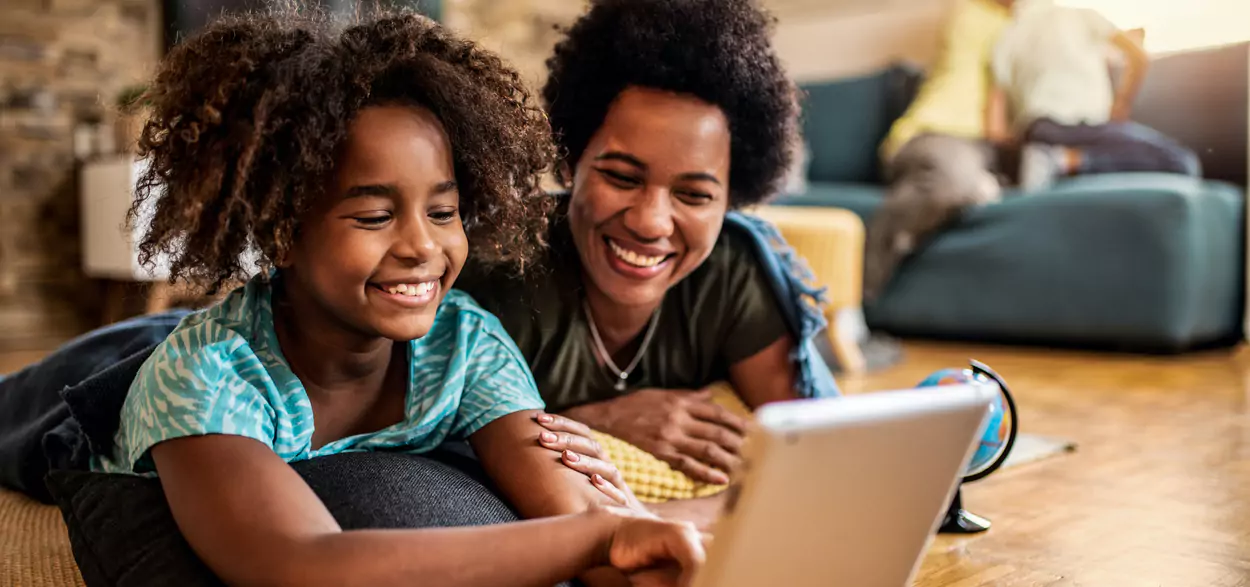 Mother and child look at a laptop together during a telehealth visit